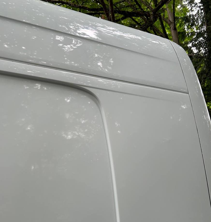 White van panel after paint correction, with a clean reflective gloss