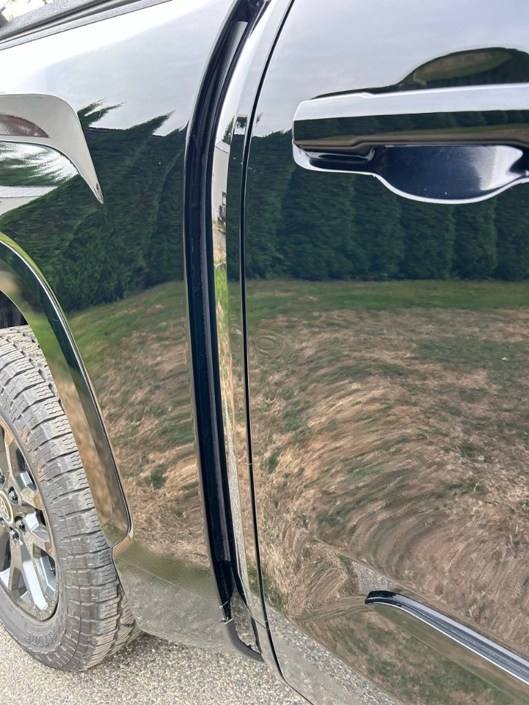 Black truck door after scratch removal and paint polishing